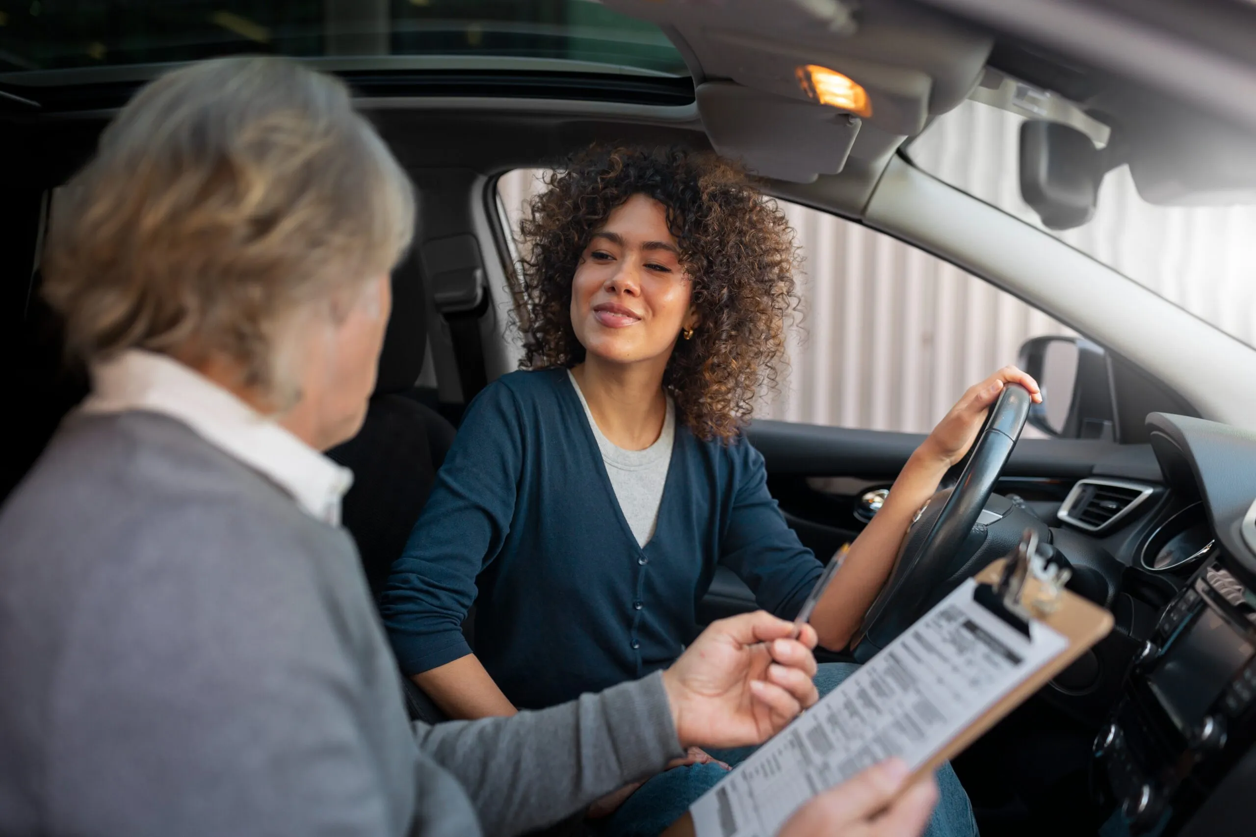Une élève souriante au volant, lors d'une leçon de conduite